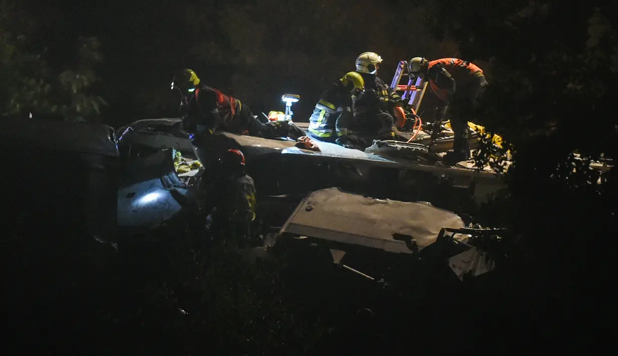 Petugas keselamatan darurat berusaha mengevakuasi korban tabrakan antara kereta penumpang dengan kereta barang di Kota Hermalle-sous-Huy, Belgia, Minggu (5/6). Akibat dari tabrakan itu, membuat 2 dari 6 gerbong terlontar dari rel. (JOHN Thys/AFP)