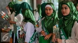 Sejumlah Simpatisan perempuan muda PPP membagikan bunga kepada pegawai dan pengunjung di Kantor Kementerian Hukum dan Ham, Jakarta, Senin (11/1). Aksi damai tersebut mendesak penyelesaian konflik pengurusan partai PPP. (Liputan6.com/Faizal Fanani)