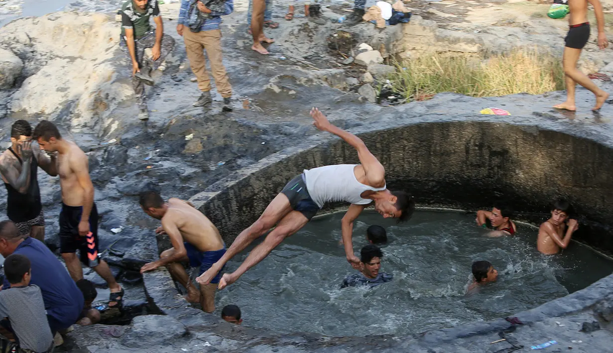 Para tentara Irak saat berada di kolam belerang di Hammam al-Ali, Mosul, Irak, (9/11). Di tengah perang melawan ISIS, mereka melepaskan penat dan lelah dengan berenang di Kolam belerang. (REUTERS/Alaa Al-Marjani)