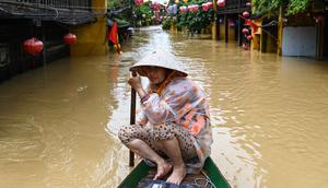 Seorang perempuan mendayung perahu di jalanan yang terendam banjir setelah hujan deras di Hoi An, Vietnam, Kamis 30 Oktober 2025. Hujan deras dengan intensitas tertinggi sepanjang sejarah memicu banjir besar di Vietnam bagian tengah. (NHAC NGUYEN/AFP)