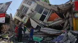 Warga mencari di antara puing-puing setelah gempa bumi melanda Pereira, Kolombia, Senin, 10 Agustus 2026. (Foto AP/Miguel Angel Lopez)