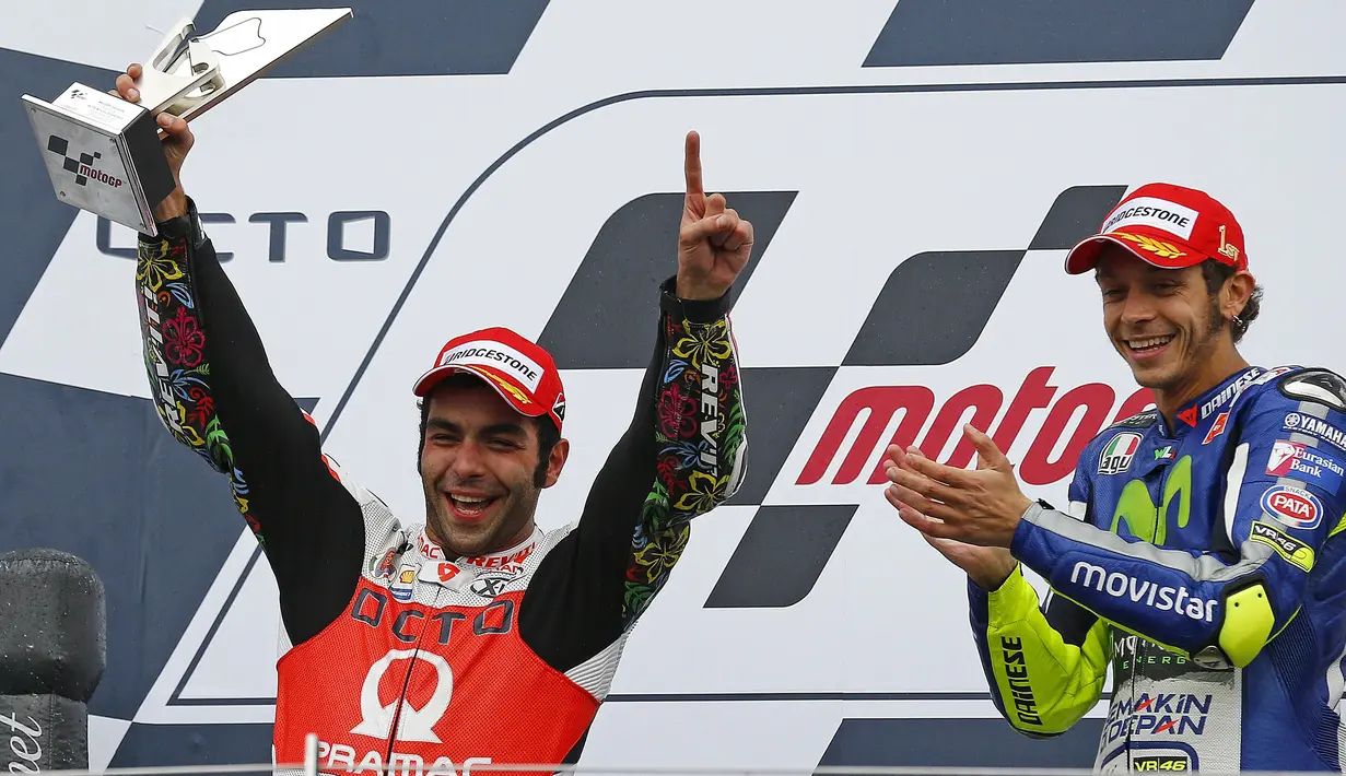 Pembalap dari Pramac Rancing, Danilo Petrucci (kiri) saat mengangkat piala juara kedua pada balapan Moto Gp seri ke-12 di sirkuit Silverstone (30/8/2015). Valentino Rossi finis pertama di seri ke-12 ini. (REUTERS/Darren Staples)