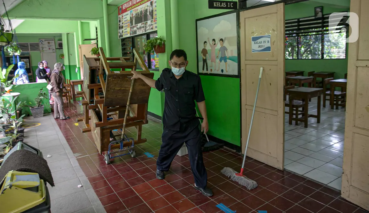 Sejumlah guru memindahkan meja di SDN Kenari 08, Jakarta, Selasa (6/4/2021). Pemerintah Provinsi DKI Jakarta akan melakukan uji coba pembelajaran tatap muka terbatas di 100 sekolah mulai 7 April hingga 29 April 2021. (Liputan6.com/Faizal Fanani)