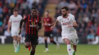 Striker Bournemouth, Dango Ouattara, berduel dengan gelandang Manchester United (MU), Bruno Fernandes, dalam laga pekan ke-33 Premier League di Vitality Stadium, Minggu (14/4/2024) dini hari WIB. Bournemouth dan MU bermain imbang 2-2. (Adrian DENNIS / AFP)