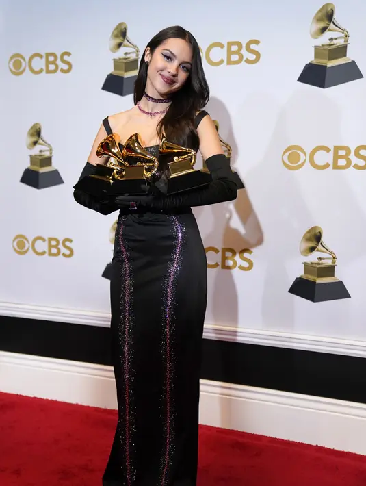 Olivia Rodrigo berpose dengan piala penghargaan Best Pop Vocal Album, Best New Artist, dan Best Pop Solo Performance pada ajang Grammy Awards 2022 di MGM Grand Garden Arena, Las Vegas, Amerika Serikat, 3 April 2022. (AP Photo/John Locher)