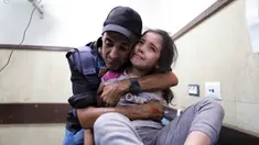 Seorang jurnalis Palestina menghibur keponakannya yang terluka dalam serangan Israel di rumah keluarganya di kamp pengungsi Nusseirat di sebuah rumah sakit di Deir el-Balah, Jalur Gaza, Minggu (22/10/2023). (AP Photo/Ali Mahmoud)