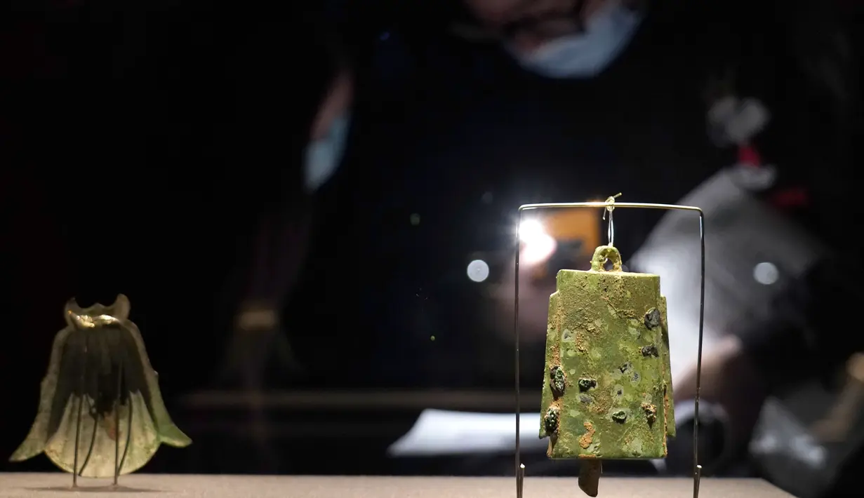 Pengunjung mengamati benda-benda yang dipamerkan dalam sebuah pameran khusus Reruntuhan Sanxingdui prasejarah yang digelar di Museum Universitas Shanghai, Shanghai, China timur, pada 21 November 2020. (Xinhua/Ren Long)