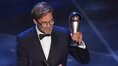Pelatih Liverpool, Jurgen Klopp mengangkat trofi Pelatih Terbaik Dunia 2019 versi FIFA saat memberi sambutan di teater La Scala Milan, Italia utara (23/9/2019). Klopp menyabet mengalahkan Pep Guardiola dan Mauricio Pochettino. (AFP Photo/Marco Bertorello)