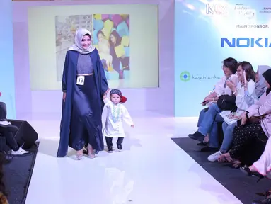 Seorang ibu bersama anaknya berjalan di atas catwalk dalam fashion show Fabalous Mom and Kids 2018 di Fimela Fuchsia Market 2018 di Kota Kasablanka, Jakarta (27/5). (Liputan6.com/Faizal Fanani)