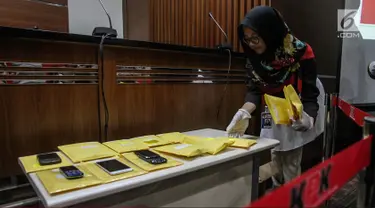 Petugas menata barang yang akan dilelang usai pemberian keterangan di Gedung KPK, Jakarta, Selasa (21/11). Sebanyak 58 obyek barang hasil rampasan koruptor akan dilelang di Gedung KPK lama pada 24 November mendatang. (Liputan6.com/Faizal Fanani)