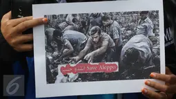 Salah satu poster yang dibawa oleh gabungan mahasiswa muslim saat aksi solidaritas save Aleppo di kawasan Bundaran HI, Jakarta, Minggu (18/12). Aksi ini menggugah kepedulian masyarakat terhadap penderitaan rakyat Suriah. (Liputan6.com/Immanuel Antonius)