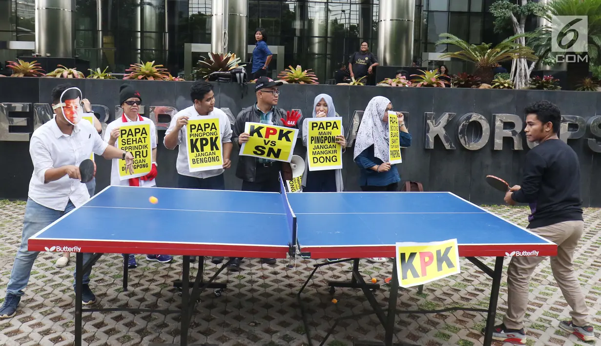 Aktivis yang tergabung dalam Koalisi Save KPK mengenakan topeng wajah Ketua DPR Setya Novanto saat menggelar aksi teatrikal bermain tenis meja melawan KPK di depan gedung KPK, Jakarta, Rabu (18/10). (Liputan6.com/Angga Yuniar)