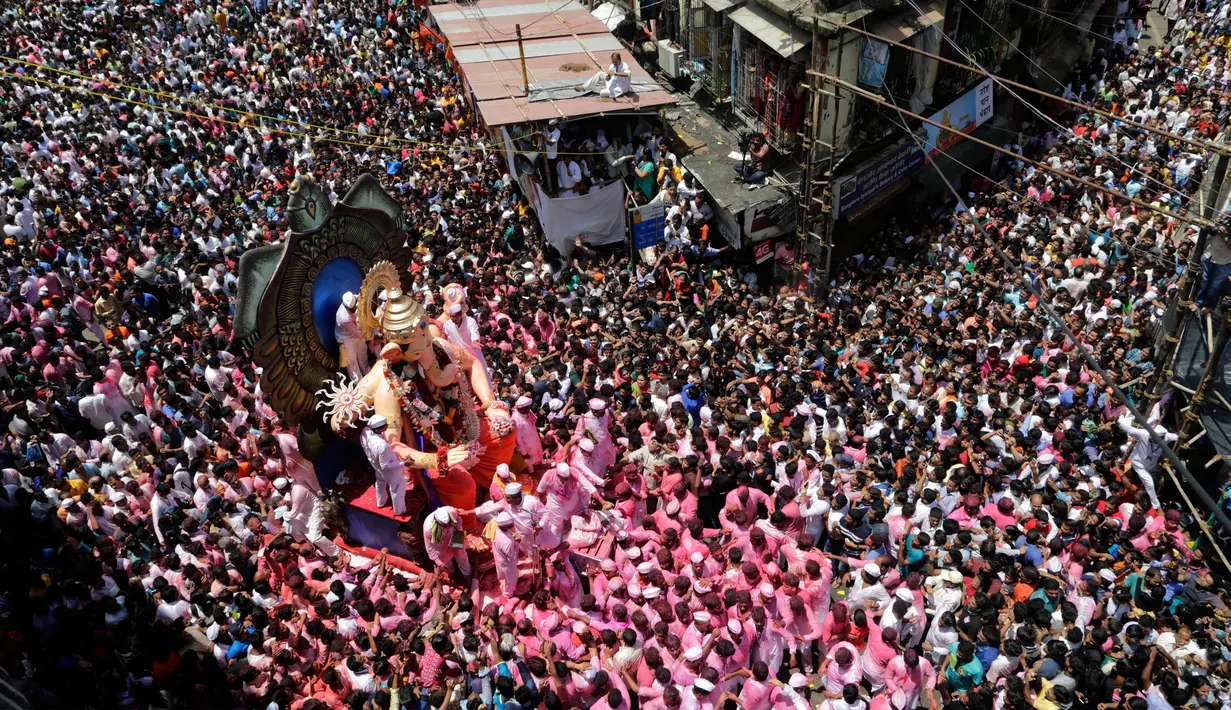 Umat hindu India mengarak patung dewa Ganesha menuju Laut Arab saat Ganesha Chaturthi di Mumbai, India, Selasa (5/9). Dalam festival ini, seluruh umat hindu India memperingati hari lahir Dewa Ganesha. (Mahesh Kumar A/AP Photo)