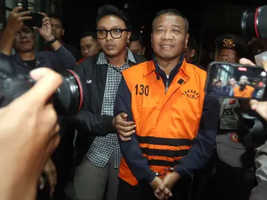 Bupati Tulungagung, Gatut Sunu Wibowo (tengah) dibawa petugas menuju mobil tahahan usai menjalani pemeriksaan intensif di Gedung Merah Putih Komisi Pemberantasan Korupsi (KPK), Jakarta, Minggu (12/4/2026) dini hari WIB. Komisi Pemberantasan Korupsi (KPK) resmi menahan Bupati Tulungagung, Gatut Sunu Wibowo beserta ajudannya, Dwi Yoga Ambal. (Liputan6.com/Helmi Fitrhiansyah)