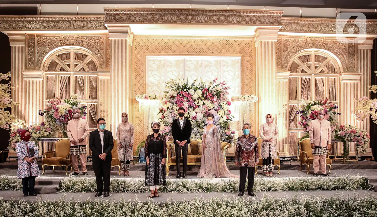 Pemakaian masker untuk pengantin dan keluarga pengantin saat simulasi penerapan protokol kesehatan resepsi pernikahan di era new normal di Jakarta, Kamis (9/7/2020). (Liputan6.com/Faizal Fanani)
