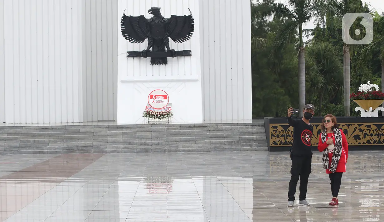Warga berswafoto di area tugu di Taman Makam Pahlawan (TMP) Kalibata, Jakarta, Rabu (10/11/2021). Hari ini banyak yang berziarah ke TMP Kalibata untuk mengingat jasa para pahlawan dan sebagai upaya memperingati Hari Pahlawan yang diperingati setiap tanggal 10 November. (Liputan6.com/Herman Zakharia)