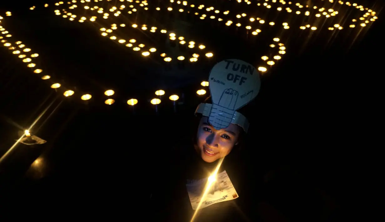 Di Surabaya Seorang wanita tampak memegangi lilin di antara ratusan lilin yang menyala membentuk angka 60. (ANTARA FOTO/Eric Ireng). 