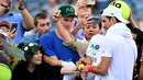 Petenis asal Serbia Novak Djokovic memberikan tanda tangan kepada para penggemar setelah sesi latihan pada hari kedua turnamen tenis Australia Terbuka di Melbourne pada 17 Januari 2023. Macam-macam barang pun disodorkan penggemar ke petenis pujaan. (MANAN VATSYAYANA / AFP)