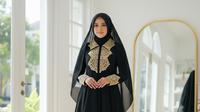 Gamis Hitam Simple Elegan Kombinasi Brokat Gold untuk Pesta Malam. (Foto: Gemini AI)
