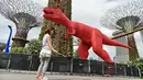 Pengunjung mengambil gambar patung dinosaurus yang terpajang di Gardens by the Bay, Singapura, Senin (28/2). Rencananya akan dipamerkan sebanyak 11 dinosaurus beraneka warna untuk merayakan Festival Anak di Singapura. (AFP PHOTO / Roslan RAHMAN)