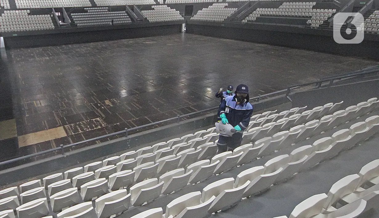 Petugas menyemprotkan cairan disinfektan pada bangku penonton di Lapangan Tennis Indoor, Kompleks Olahraga GBK (Gelora Bung Karno), Senayan, Jakarta, Kamis (19/3/2020). Penyemprotan untuk mencegah penyebaran Virus Corona Covid-19 di Lingkungan Kompleks Olahraga GBK. (Liputan6.com/Herman Zakharia)