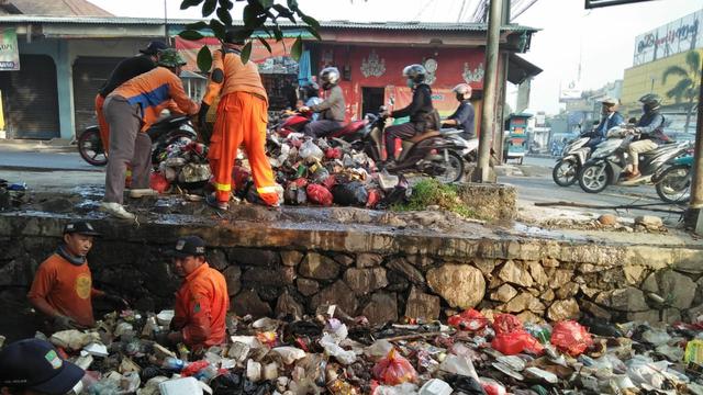 Petugas membersihkan tumpukan sampah kali Abu Bakar Bekasi (Bam Sinulingga/Liputan6.com)