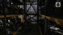 Pekerja menurunkan sepeda motor di Soul Parking, Kebon Kacang, Jakarta, Jumat (21/1/2022). Tempat parkir vertikal tersebut menerapkan sistem teknologi Compact Motor Storage atau sistem rak bersusun dengan lift barang. (Liputan6.com/Faizal Fanani)