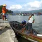 Nelayan di Teluk Popoh, Tulungagung, memperbaiki jaring dan perahu selama tak bisa melaut akibat cuaca buruk (Zainul Arifin/Liputan6.com)