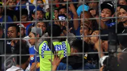Personel polisi berusaha menenangkan suporter saat laga final Piala Bhayangkara 2016 antara Arema Cronus vs Persib di Stadion GBK Jakarta, Minggu (3/4/2016). Laga diwarnai aksi protes dari suporter dan official Persib. (Liputan6.com/Helmi Fithriansyah)
