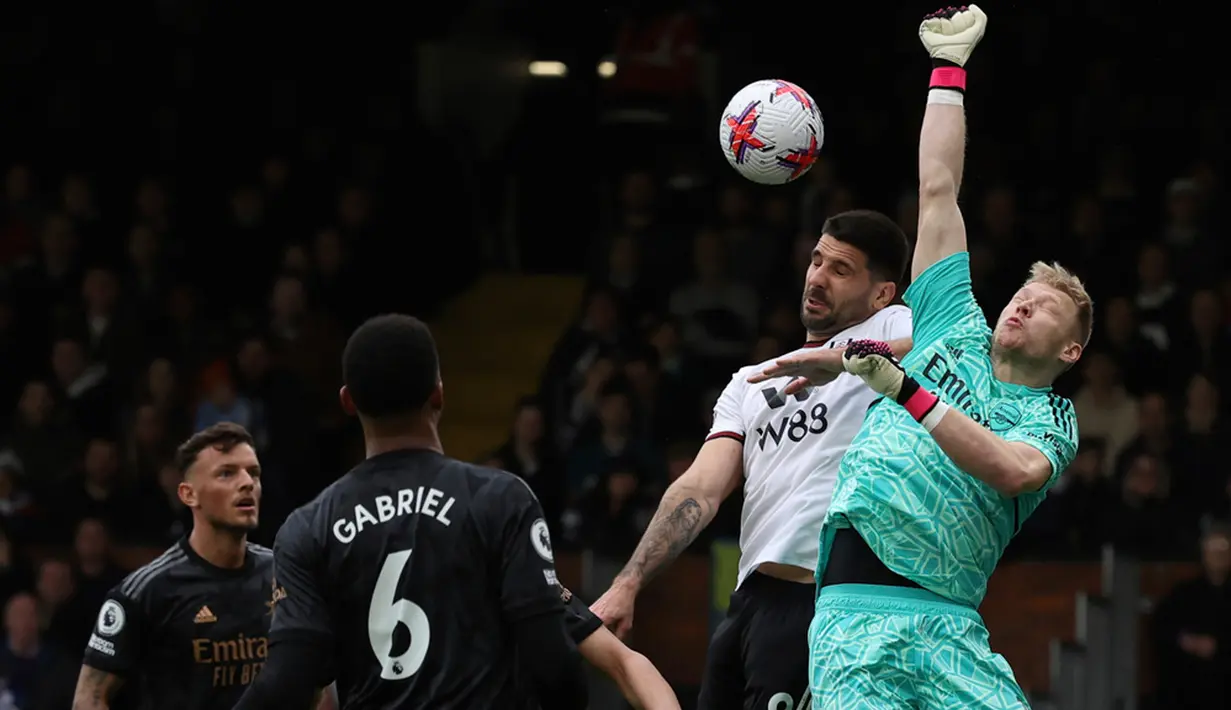 Kiper Arsenal Aaron Ramsdale (kanan) melakukan penyelamatan di depan pemain Fulham Aleksandar Mitrovic pada pertandingan sepak bola Liga Inggris di Stadion Craven Cottage, London, 12 Maret 2023. Arsenal mengalahkan Fulham dengan skor 3-0. (AP Photo/Ian Walton)