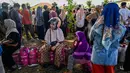 Kelangkaan gas di Kota Banda Aceh memicu kritik tajam dari berbagai pihak. Tampak dalam foto, warga menunggu untuk membeli tabung gas di sebuah stasiun pengisian dan pembelian LPG setelah banjir bandang di Banda Aceh pada Rabu 17 Desember 2025. (CHAIDEER MAHYUDDIN/AFP)