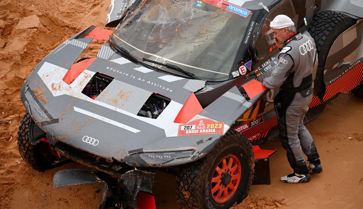 Luca Cruz yang dibantu oleh mekanik Audi berusaha memperbaiki mobil agar Sainz bisa melanjutkan balapan. (AFP/Franck Fife)