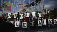 Sejumlah perempuan memegang surat yang membentuk frase "Legal Abortion Now" dalam protes hak-hak aborsi di Quito, Ekuador, Senin (28/9/2020). (AP Photo/Dolores Ochoa)