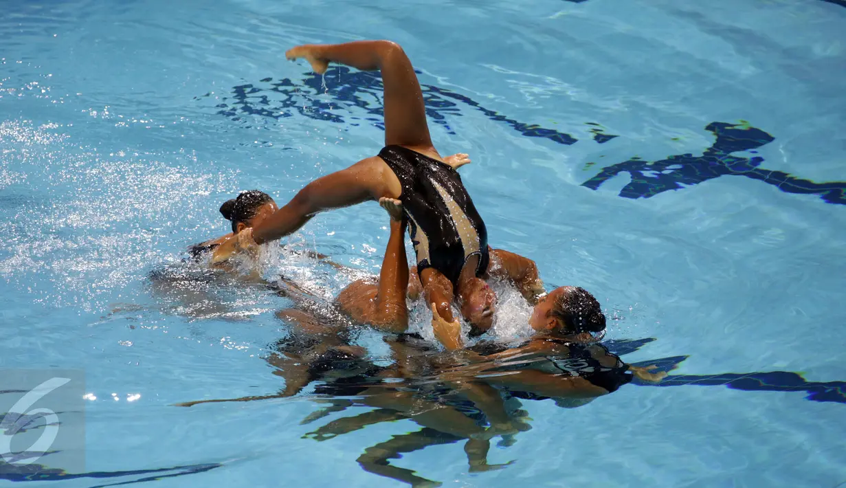 Tim renang indah Indonesia berhasil menyumbang medali pertama bagi kontingen Merah Putih di Sea Games 2015 Singapura. Salah satu anggota tim melakukan salto saat tampil di OCBC Aquatic Centre, Rabu (3/6/2015). (Liputan6.com/Helmi Fithriansyah)   
