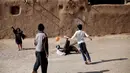Anak-anak Afganistan bermain bola di tempat pengungsian Shahid Nasseri, Desa Taraz Nahid, 130 km dari Teheran,Minggu (8/02/2015). (AFP Photo/Behrouz Mehri)
