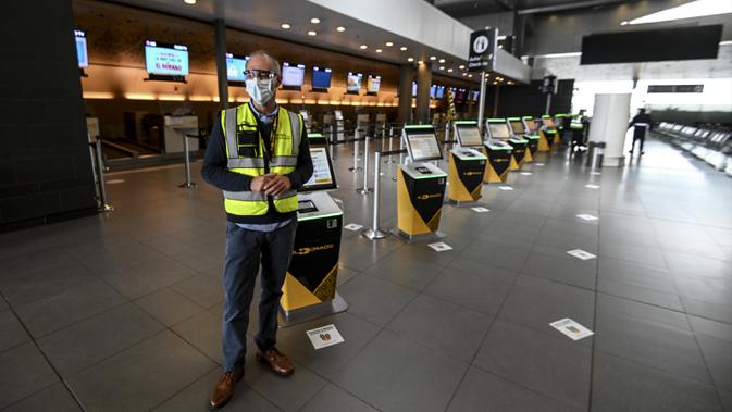 Seorang pekerja berdiri di area check-in Bandara Internasional El Dorado, Bogota, Kolombia, Senin (31/8/2020). Presiden Kolombia Ivan Duque mengizinkan lebih banyak penerbangan domestik mulai September. (Juan BARRETO/AFP)