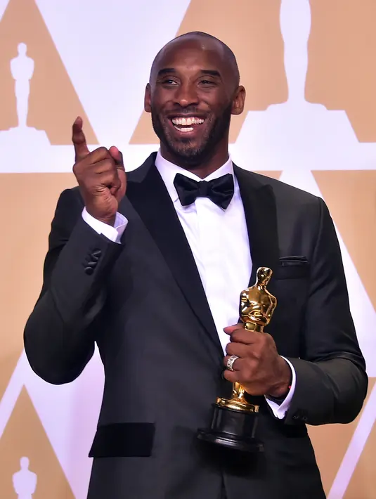 Kobe Bryant berpose sambil memegang Piala Oscar 2018 usai meraih penghargaan di Academy Awards ke-90 di Hollywood, California (3/4). Bryant berhasil merebut satu piala untuk kategori film animasi pendek terbaik. (AFP/Frederic J. Brown)