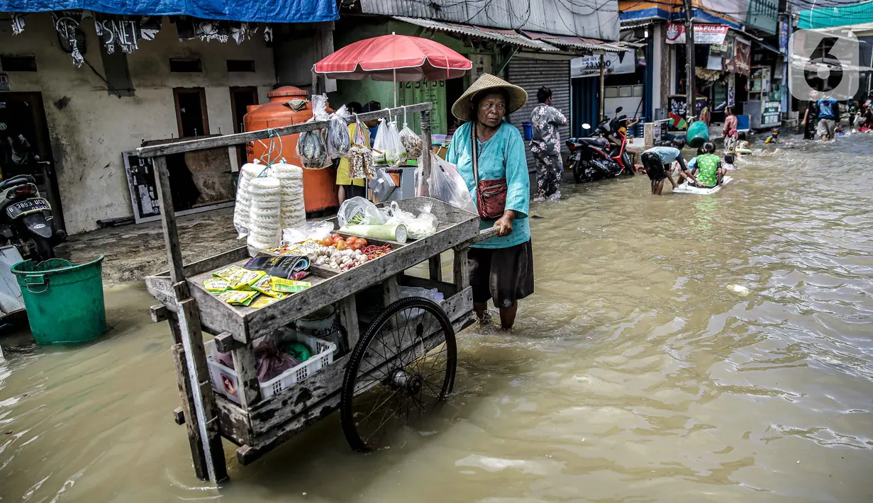 Pedagang sayur berjualan saat banjir rob di kawasan Muara Angke, Jakarta, Selasa (9/11/2021). Badan Penanggulangan Bencana Daerah (BPBD) DKI Jakarta memperkirakan puncak musim hujan dan potensi rob di Ibu Kota terjadi pada Januari hingga Februari 2022. (Liputan6.com/Faizal Fanani)