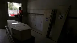 Seorang relawan duduk di dekat jendela sambil menunggu sejumlah jenazah korban gelombang panas untuk diidentifikasi, di sebuah kamar mayat di Karachi, Pakistan, Senin (22/6/2015). (REUTERS/Akhtar Soomro)