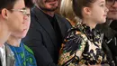 David Beckham bersama anak-anaknya Romeo Beckham, Cruz Beckham dan Harper saat menghadiri peragaan busana Musim Gugur/Musim Dingin 2020 Victoria Beckham dalam acara London Fashion Week di London, (16/2/2020). Beckham tampil dengan setelan jas hitam. (AFP/Daniel Leal-Olivas)