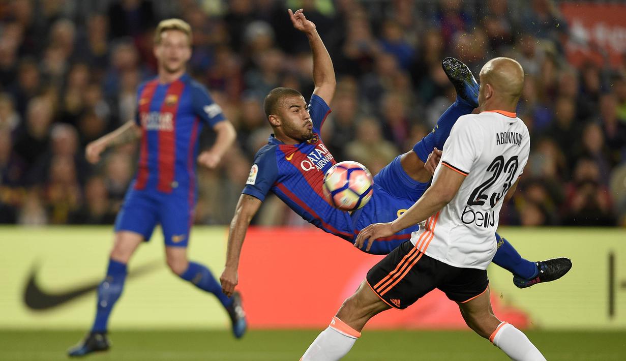 Bek Barcelona, Rafinha, membuang bola dari kejaran bek Valencia, Aymen Abdennour. Pada laga ini Luis Enrique menurunkan Barcelona dengan formasi andalannya 3-4-3, sementara Valencia turun dengan skema 4-3-3. (AFP/Lluis Gene)