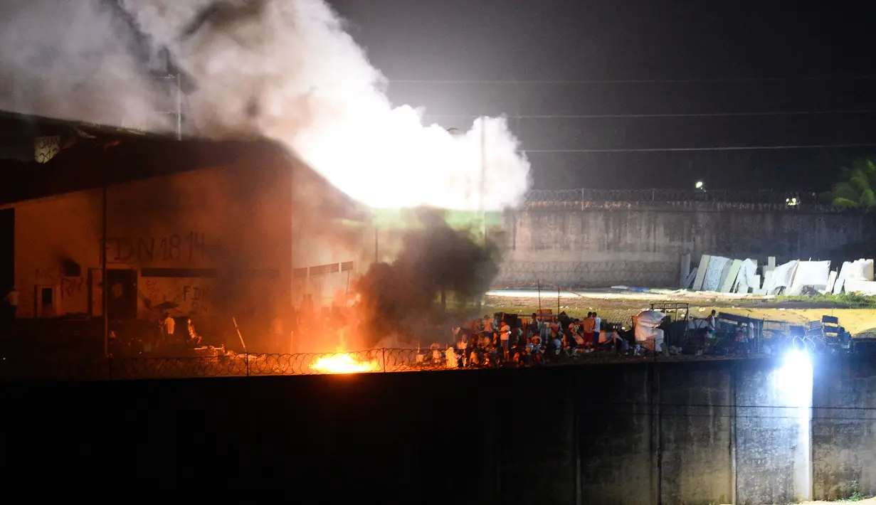 Sejumlah narapidana berkumpul selama kerusuhan susulan yang terjadi di Penjara Alcaruz , Natal, Rio Grande do Norte, Brasil, Senin (17/1). Bentrokan ini berlanjut dari pembantaian beberapa hari lalu yang menewaskan 26 orang. (AFP Photo/Andressa Anholette)