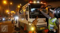 Petugas memberhentikan bus kota karena menaikan penumpang diatap bus saat malam takbiran di kawasan Matraman, Jakarta Timur, Jum’at (17/7/2015) malam. Tindakan tersebut dapat membahayakan keselamatan penumpang dan orang lain.(Liputan6.com/Faisal R Syam)