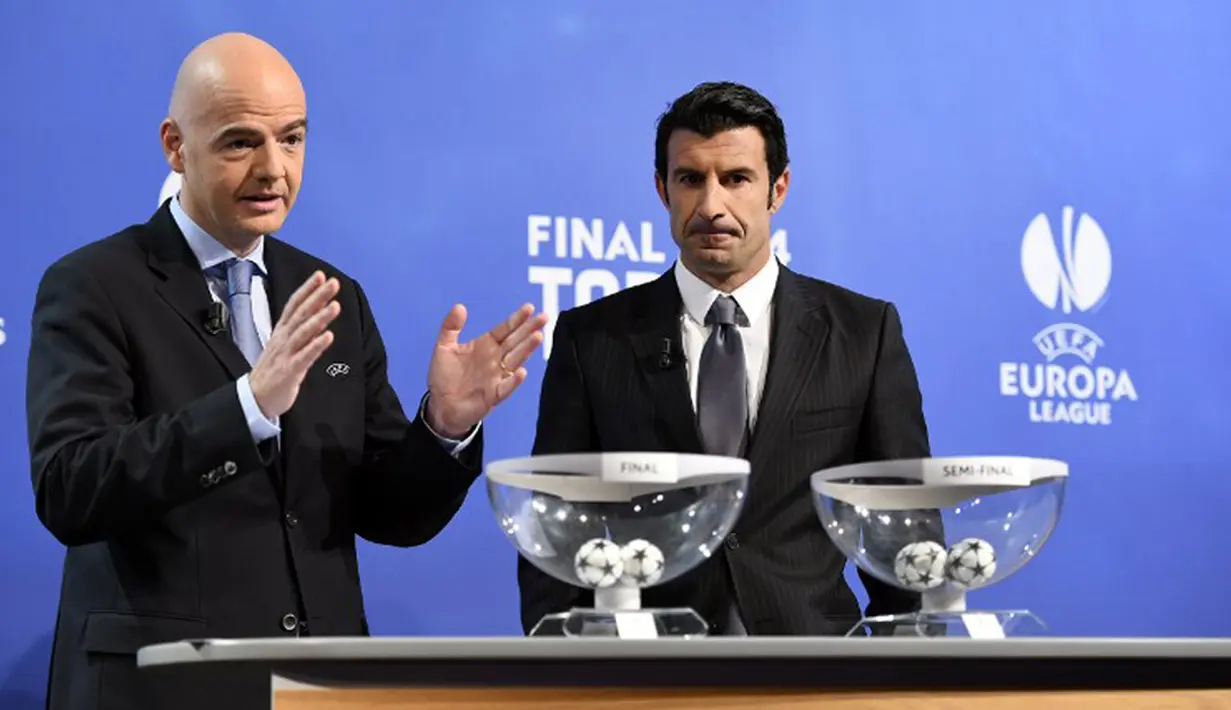 Sekretaris Jenderal UEFA Gianni Infantino (kiri) dan mantan bintang Real Madrid,   Luis Figo, mengambil bagian dalam undian untuk semifinal sepakbola Liga Champions di   markas UEFA di Nyon pada Jumat 11 April 2014 (AFP PHOTO/FABRICE COFFRINI)