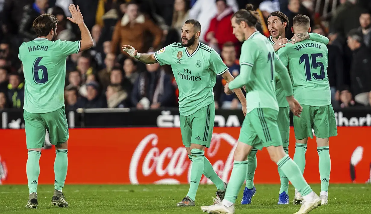 Penyerang Real Madrid, Karim Benzema (kedua kiri) berselebrasi dengan rekan-rekannya usai mencetak gol ke gawang Valencia pada pertandingan lanjutan La Liga Spanyol di Stadion Mestalla (15/12/2019). Benzema mencetak gol pada menit (90+5) dan membuyarkan kemenangan Valencia. (AP Photo/Alberto Saiz)