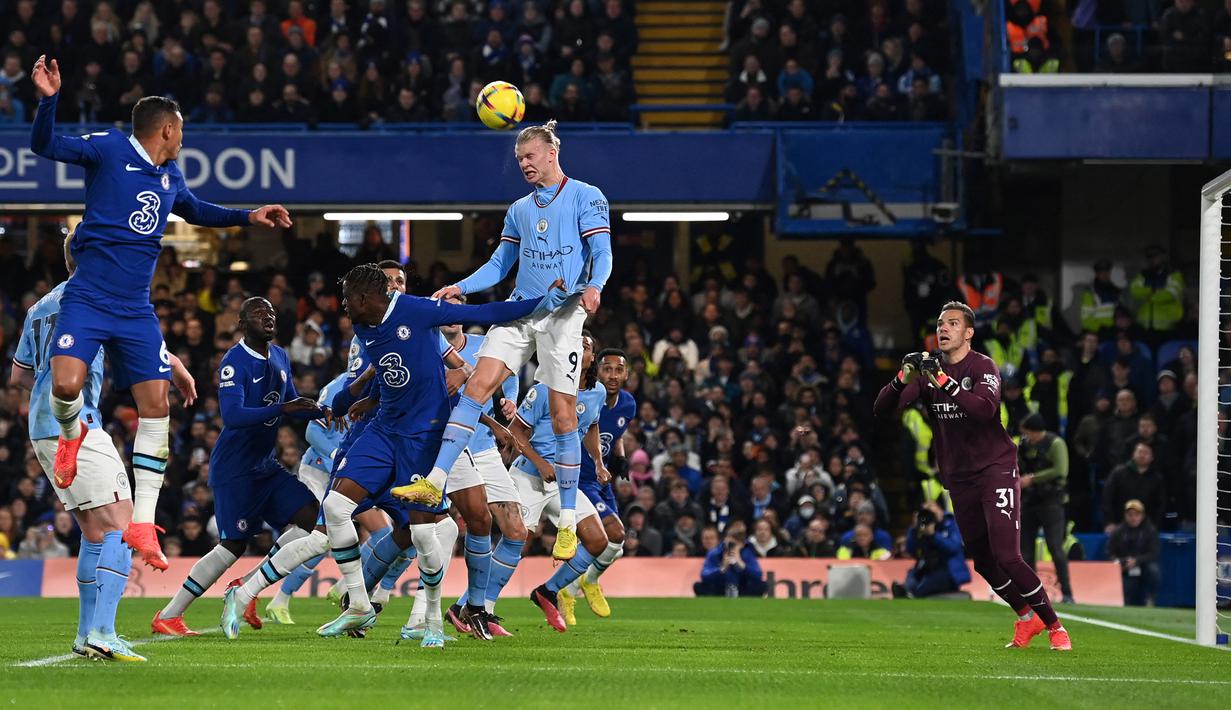 Striker Manchester City, Erling Haaland melompat untuk menghalau bola saat menghadapi Chelsea pada laga Liga Inggris 2022/2023 di Stamford Bridge, London (5/1/2023). Erling Haaland juga belum mampu mencetak gol ke gawang Chelsea. Pada pertemuan pertama di pekan ke-19, meski Man City menang 1-0, namun Erling Haaland gagal menyumbang gol. (AFP/Glyn Kirk)