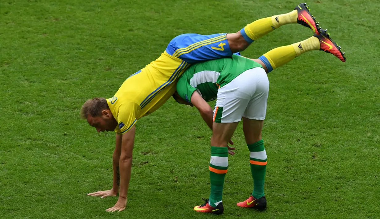 Pemain Irlandia, Shane Long (kanan), duel dengan pemain Swedia, Andreas Granqvist, dalam laga Grup E Piala Eropa 2016 di Stade de France, Saint-Denis, (13/6/2016). (AFP/Paul Ellis)