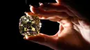 <p>'The Red Cross Diamond', sebuah berlian mewah berwarna kuning pekat berbentuk bantal dengan berat 205,07 karat yang akan ditawarkan oleh Rumah Lelang Christie di Jenewa, Swiss, 11 Mei 2022. Sebagian dari hasil penjualan berlian akan disumbangkan kepada Komite Palang Merah Internasional. (Fabrice COFFRINI/AFP)</p>