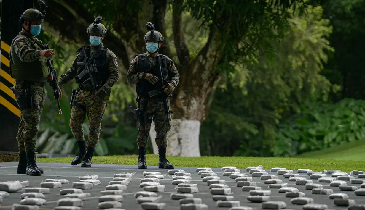 Anggota Layanan Perbatasan Nasional Panama menjaga paket ganja sitaan saat konferensi pers di Pangkalan Senafront Gamboa, Panama City, Panama, 1 September 2019. Militer Panama menyita 785 kilogram ganja selama operasi antinarkotika di perbatasan maritim dengan Kolombia. (Luis Acosta/AFP)