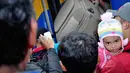 Seorang pria tampak menggendong anak kecil saat berdesakan masuk ke dalam kereta di Stasiun Senen, Jakarta, Kamis, (24/7/14). (Liputan6.com/Faizal Fanani)